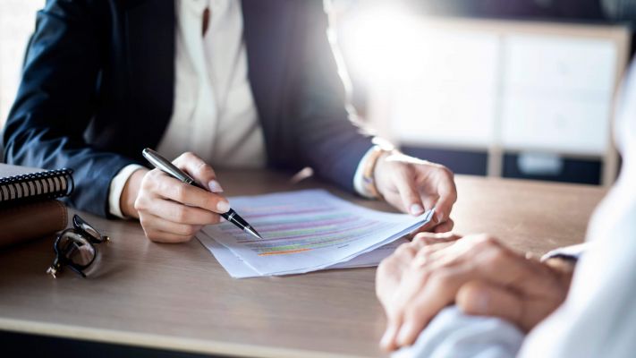 2 people dressed in business professional clothing reviewing paperwork