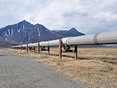 A pipeline going through the desert surrounded by mountains