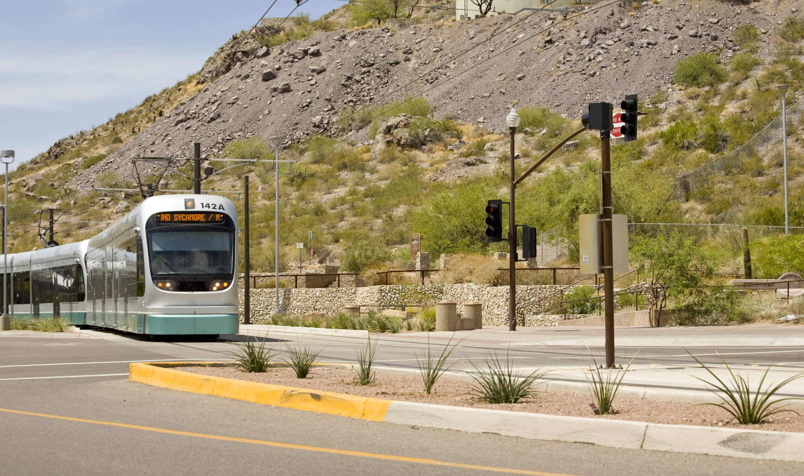 A silver tram crossing the street