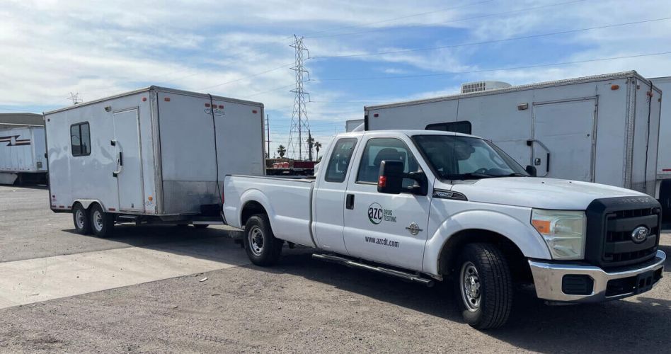 White AZC Drug Testing truck towing a white trailer