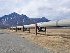 A pipeline going through the desert surrounded by mountains