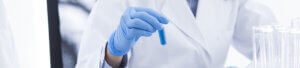 Lab technician holding a test tube with blue liquid