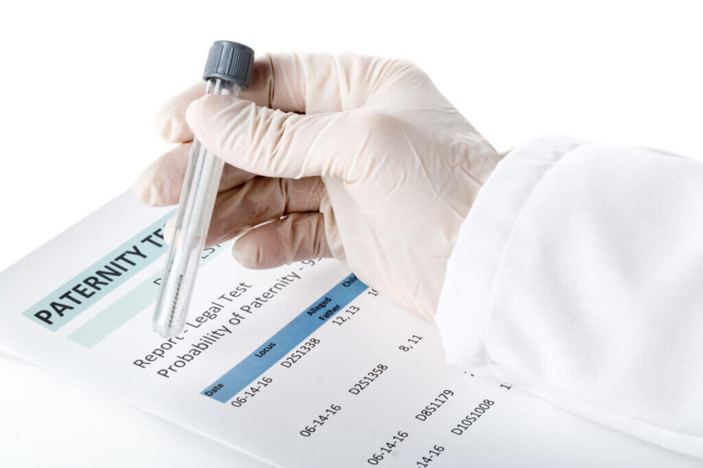 A medical professional holding a test tube for a paternity test