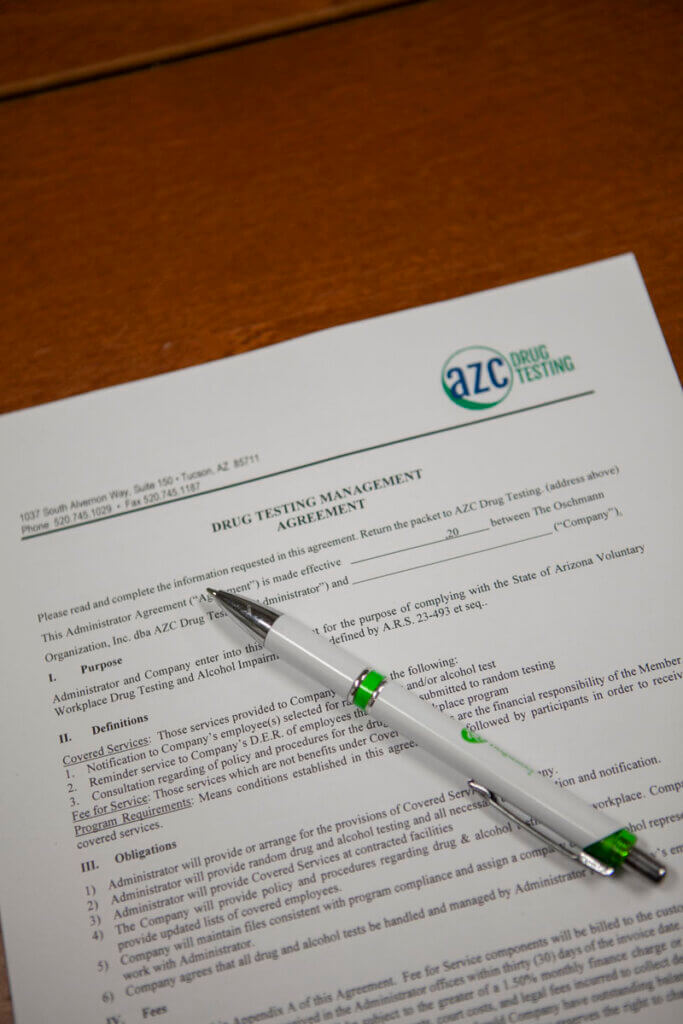 Drug testing management agreement form on a table to be signed