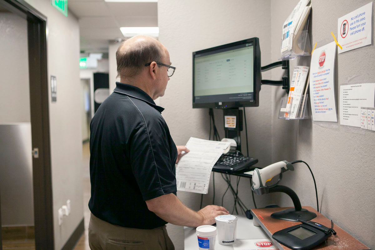 About Us A male medical professional inputting patient results into a computer