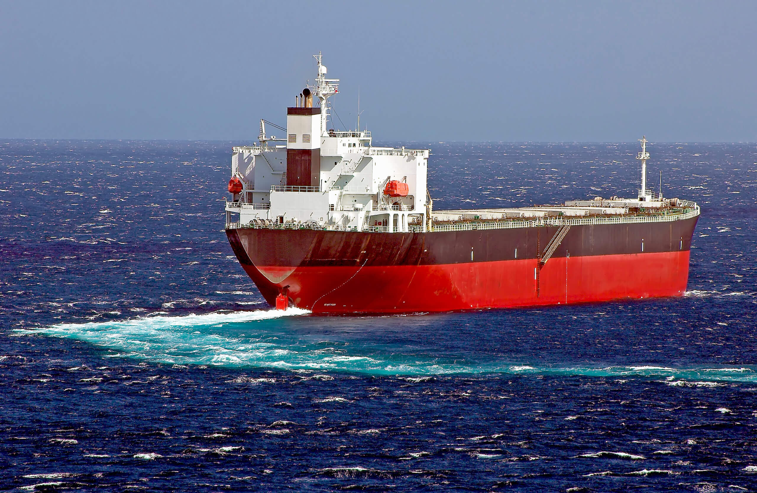 A cargo ship sailing on a white-capped ocean