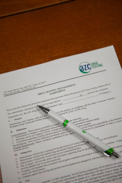 AZC Drug Testing - Collection Sites Drug testing management agreement form on a table to be signed