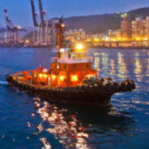 A tug boat on a river through a city