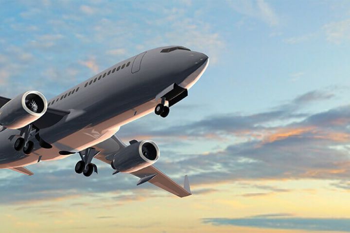 Airplane shortly after takeoff flying at sunset