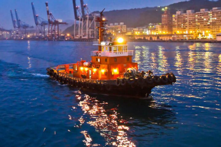 A tug boat on a river through a city