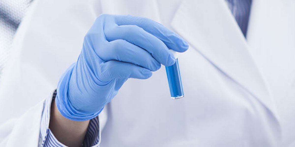 Lab technician holding a test tube with blue liquid