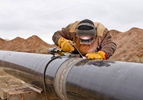 Welder working on an outdoor pipeline