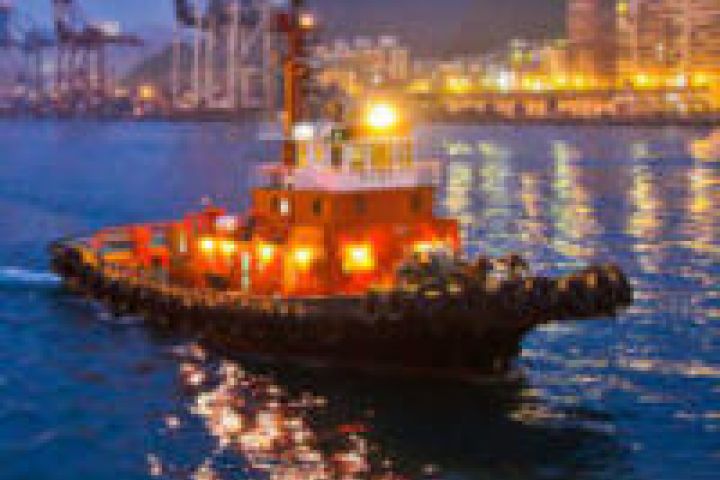 A tug boat on a river through a city