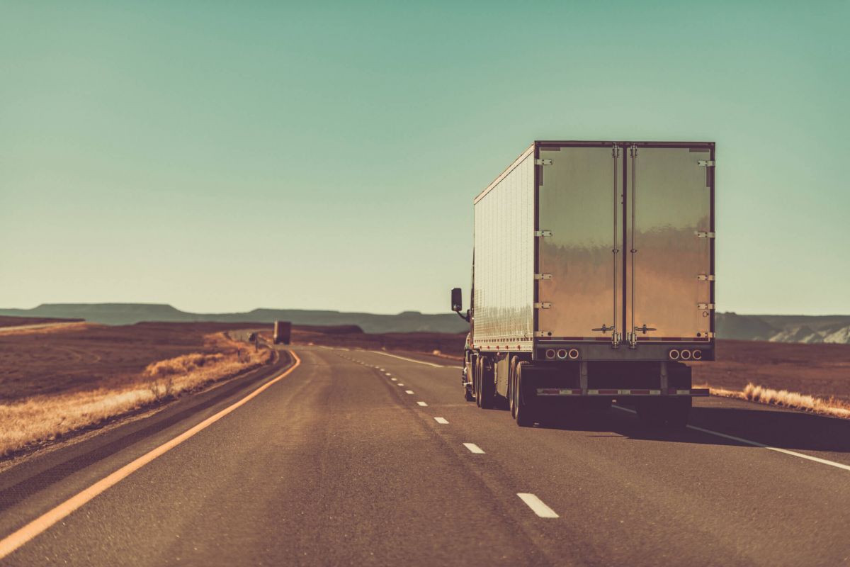 2 semi-trucks driving through the desert in Arizona