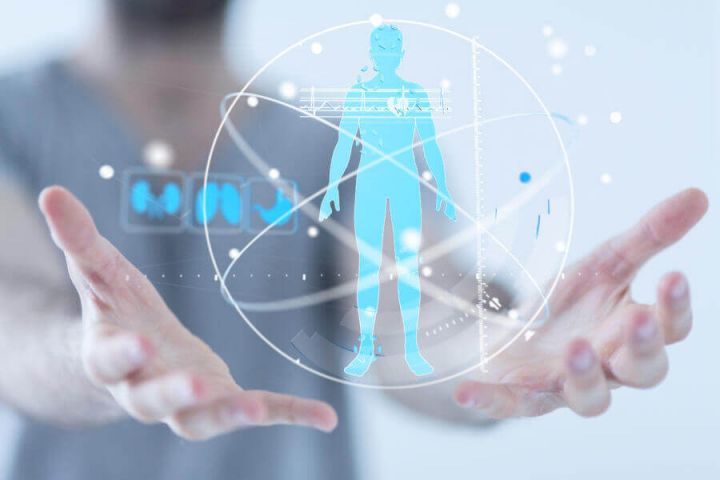A man in scrubs holding a digital rendering of a human body