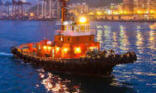 A tug boat on a river through a city