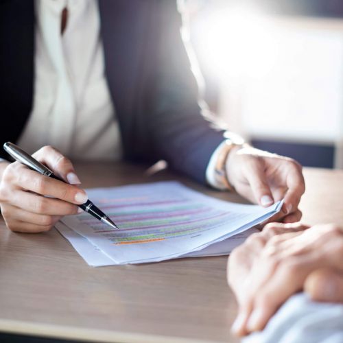 2 people dressed in business professional clothing reviewing paperwork