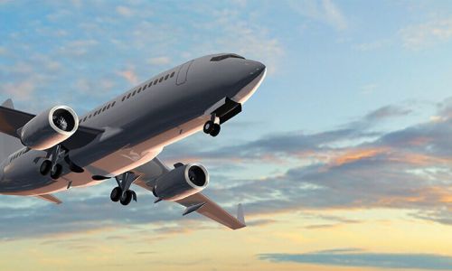 Airplane shortly after takeoff flying at sunset