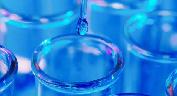 Dropper placing a drop of liquid into a test tube