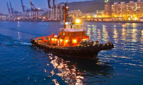 A tug boat on a river through a city
