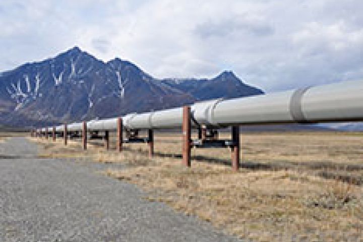 A pipeline going through the desert surrounded by mountains